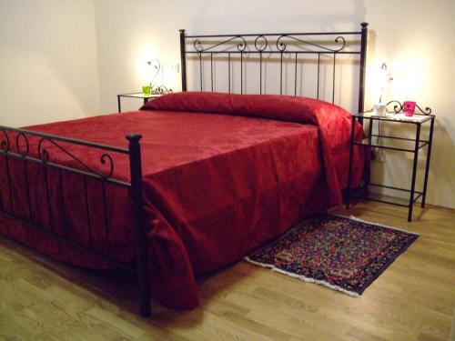 a bedroom with a bed with a red blanket at Tre Girasoli in Monte San Savino
