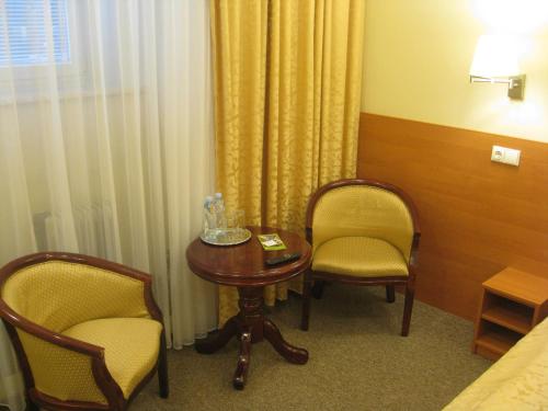 a room with two chairs and a table and a bed at Silvija House in Vilnius