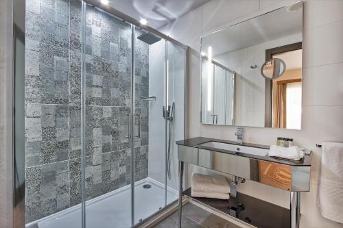 uma casa de banho com uma cabina de duche em vidro e um lavatório. em Palazzo Rosaria Boutique Hotel em Valletta