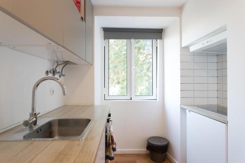 a kitchen with a sink and a window at FLH Lx Factory Modern Flat in Lisbon