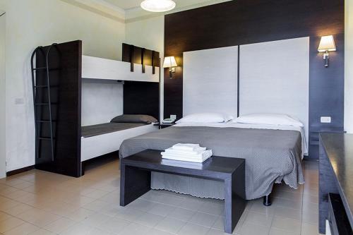 um quarto com 2 beliches e uma mesa em Hotel La Palma em Lido di Camaiore