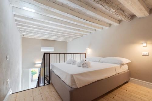 una camera da letto con un grande letto bianco con cuscini bianchi di Borgo Pinti Garden Suite a Firenze