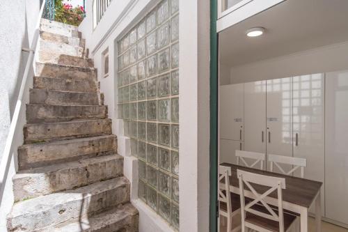 een trap met een tafel naast een glazen wand bij LV Premier Bica in Lissabon