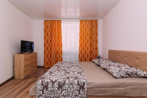 1 dormitorio con 1 cama, TV y ventana en Apart-hotel on Kondrateva street New Building, en Sumy