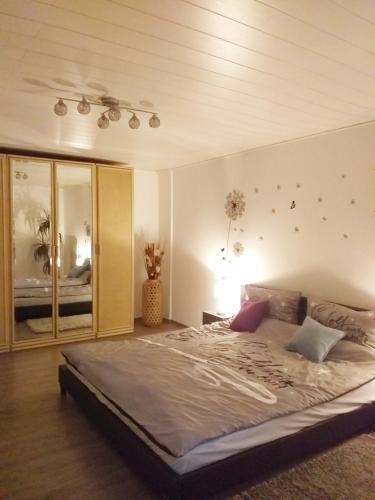 Schlafzimmer mit einem großen Bett und einer Decke in der Unterkunft Ferienwohnung im Rottal in Oberrot