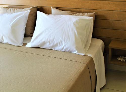 a bed with white pillows on top of it at Kefalonian Oneira Villas in Mousata