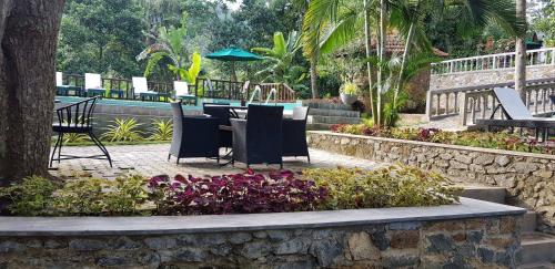 a table and chairs in a garden with flowers at Ella Planters Bungalow in Ella