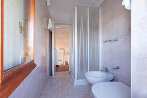 a bathroom with a toilet and a glass shower at Residence Elle in San Benedetto del Tronto