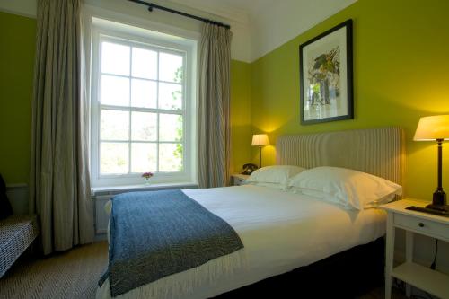 um quarto com uma cama grande e uma janela em The Manor at Sway – Hotel, Restaurant and Gardens em Sway