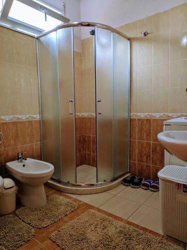 a bathroom with a shower and a toilet and a sink at All Seasons Apartments - Free Parking & City Center in Shkodër