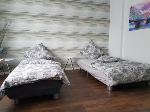 a room with two beds and a painting on the wall at Apartment Alt-Refrath in Bergisch Gladbach