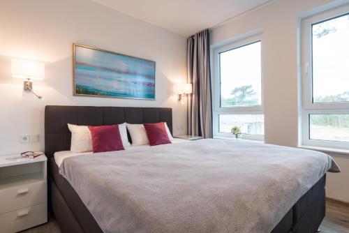 1 dormitorio con 1 cama grande con almohadas rojas en Appartement "Diamant" mit Penthouseflair - Oase am Haff, en Garz
