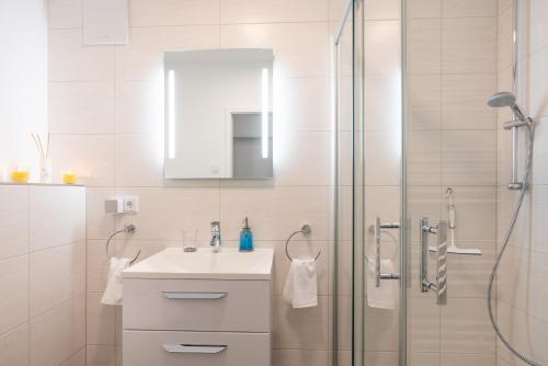 a white bathroom with a sink and a shower at Appartement "Diamant" mit Penthouseflair - Oase am Haff in Garz