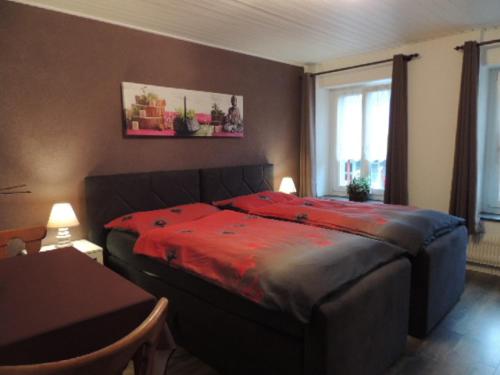 1 dormitorio con 1 cama con manta roja en Hotel de la Gare, en Cousset 