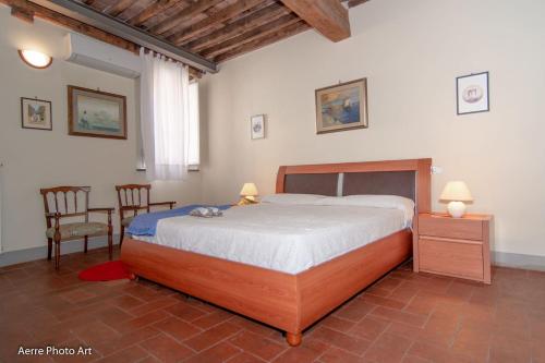 een slaapkamer met een groot bed en 2 stoelen bij Casa Gemma in Lucca