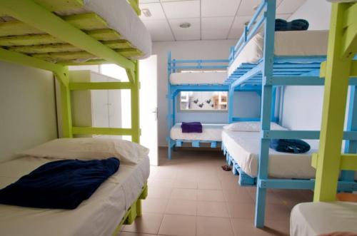 a room with three bunk beds and a ladder at Pura Vida Las Palmas in Las Palmas de Gran Canaria