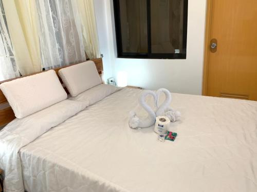 a bed with a stuffed animal sitting on it at LUNA OSLOB TRAVELLERS INN - Beach Front in Oslob