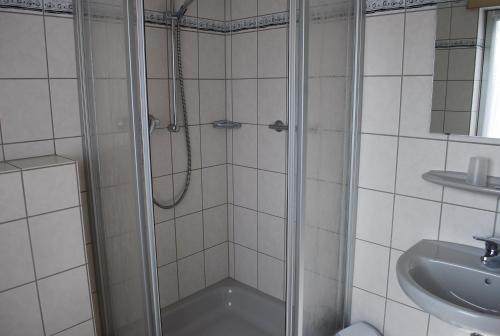 y baño con ducha y lavamanos. en Hotel Restaurant Gilles, en Kollig