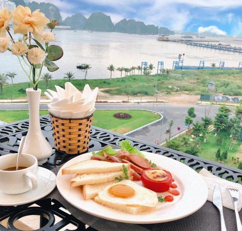 a table with a plate of breakfast food and a cup of coffee at Vincent Halong Hotel in Ha Long