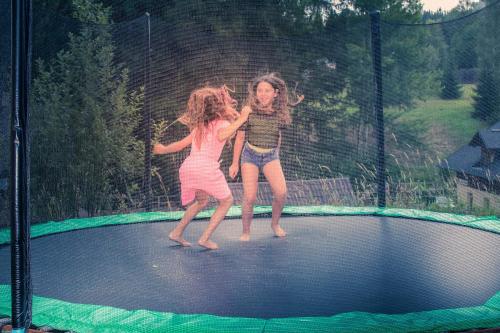 two young girls playing on a trampoline at Pension Familia in Harrachov