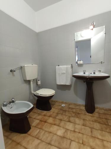 a bathroom with a toilet and a sink at Mafra Guest House in Mafra