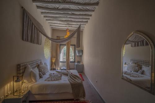a bedroom with a large mirror and a bed at Taj Atlas Wellness Boutique Hôtel & Spa in Amizmiz