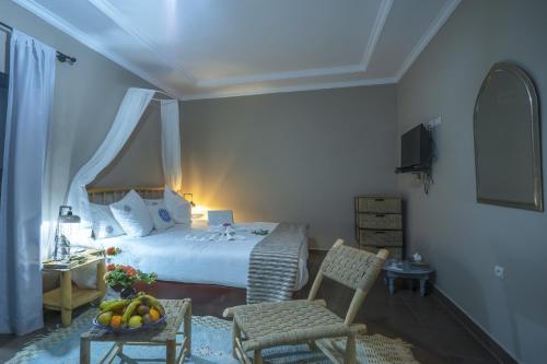 a bedroom with a bed and a table with a bowl of fruit at Taj Atlas Wellness Boutique Hôtel & Spa in Amizmiz