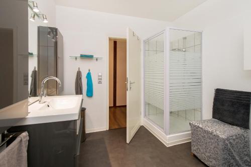 uma casa de banho com um lavatório e uma cabina de duche em vidro. em Rhinkieker Rees em Rees