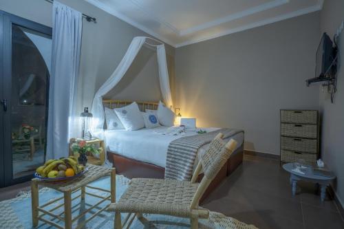 a bedroom with a bed and a table with a bowl of fruit at Taj Atlas Wellness Boutique Hôtel & Spa in Amizmiz