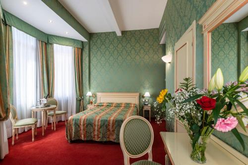a hotel room with a bed and a table at Hotel Villa Delle Palme in Venice-Lido