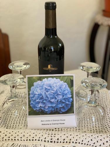 a bottle of wine with a blue flower on a table at Grannys House in Angra do Heroísmo