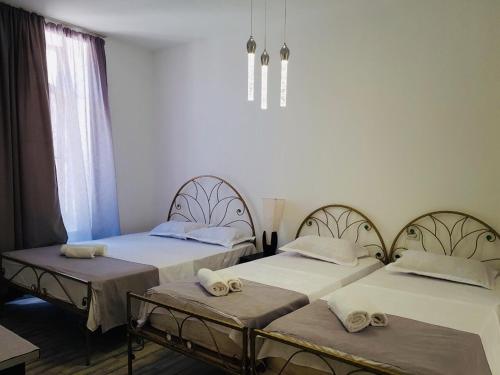 two twin beds in a room with a chandelier at kessane in Akhaltsikhe