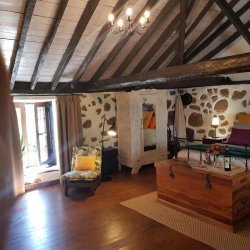a living room with a bed and a couch and a table at Elescondite in Sauzal
