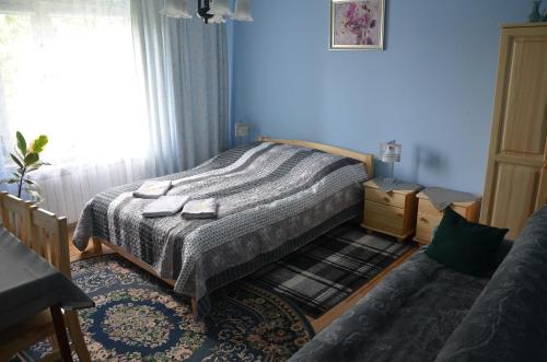 a bedroom with a bed in a blue room at Pokoje Gościnne Szuber in Iwonicz-Zdrój