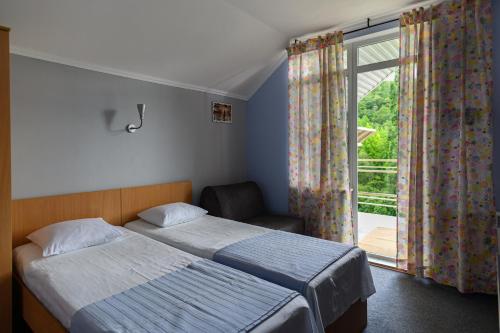 a bedroom with a bed and a chair and a window at Yellow House in Yakornaya Shchel