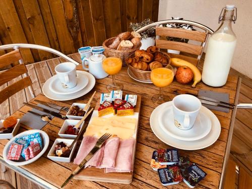 Una mesa con alimentos para el desayuno y leche sobre ella. en Hôtel du Lac d'Arjuzanx, en Arjuzanx