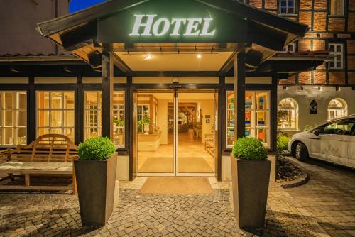 a hotel with two potted plants in front of a building at Romantik Hotel am Brühl in Quedlinburg