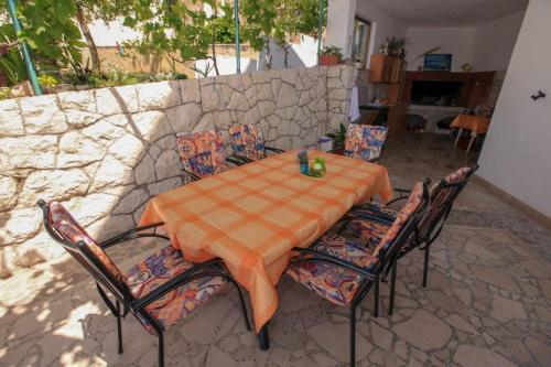 een tafel en stoelen en een stenen muur bij Apartments Palmero in Gradac