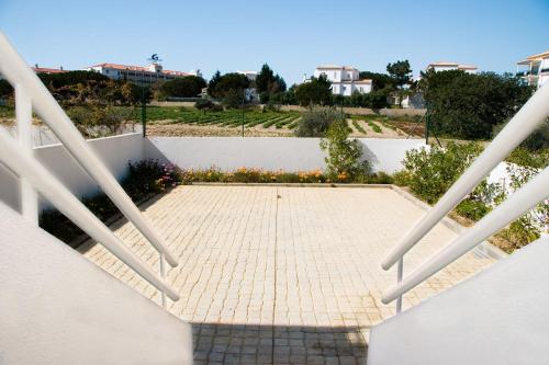 a staircase with white railings and a brick walkway at Os Apartamentos A Ramos na Praia da Galé Estão inserido em Condomínio com PISCINA, Fica apenas a 350 Metros da Praia da Galé - Apartamentos com Ar Condicionado tanto nos Quartos como na Sala, Smart TV com Prime Vídeo e Cozinha Completa in Albufeira