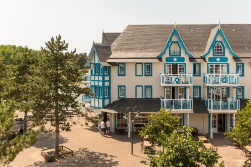 a large blue building with people walking in front of it at Village Pierre & Vacances Belle Dune in Fort-Mahon-Plage