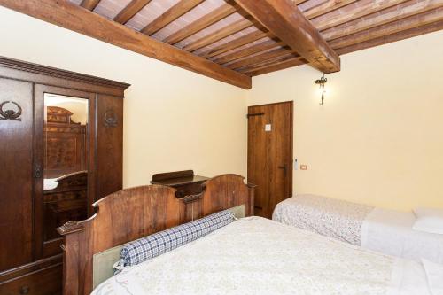 a bedroom with two beds and a wooden ceiling at Podere Caldaruccio La Pineta in Bosco