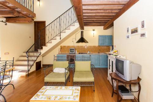 a kitchen with blue cabinets and a tv in a room at Podere Caldaruccio La Pineta in Bosco