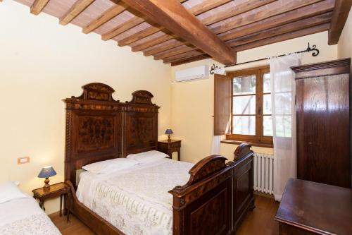 a bedroom with a large wooden bed and a window at Podere Caldaruccio La Pineta in Bosco