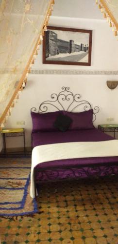 een bed in een kamer met een foto aan de muur bij Riad Anass Al Ouali in Fès