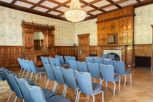 a room with chairs and a fireplace and a chandelier at Pendley Manor in Tring