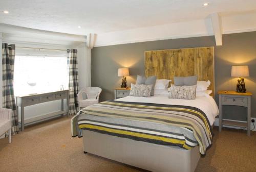 
a hotel room with a large bed and a large window at Hunters Lodge Inn in Totnes
