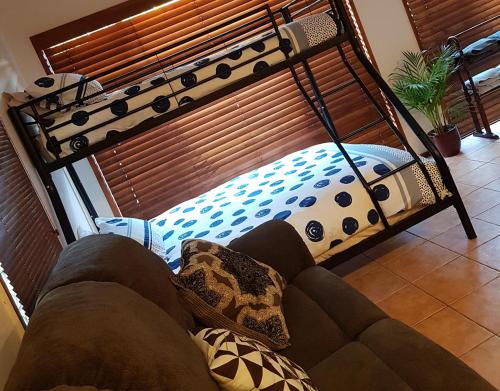 a bed in a living room with a bunk bed at Theme Park Getaway in Gold Coast
