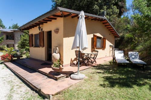 a patio with an umbrella and a table and chairs at Podere Caldaruccio La Pineta in Bosco