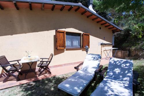 two chairs and a table in front of a house at Podere Caldaruccio La Pineta in Bosco