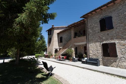 a stone building with a chair in front of it at Podere Caldaruccio La Pineta in Bosco